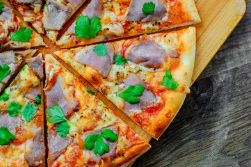 Pizza with Mozzarella cheese, ham, pepper, meat, Tomato sauce, Spices. Italian pizza on wooden...