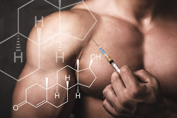 Muscular man with a syringe in his hand and testosterone formula.