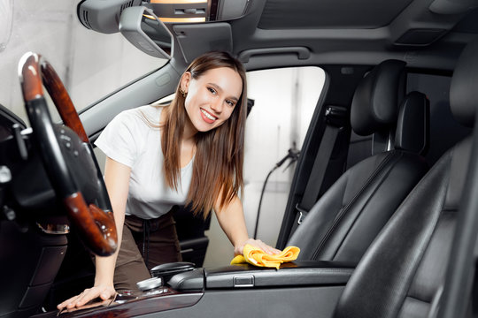 Car wash service, girl worker cleaning interior modern microfiber and console auto - Powered by Adobe
