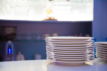 many white plates are placed in the foreground.