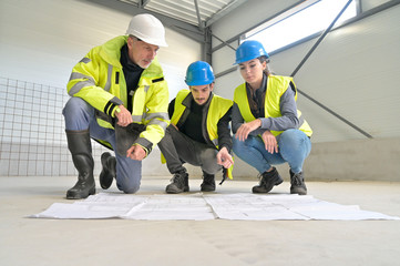Engineering instructor working on building site with apprentice