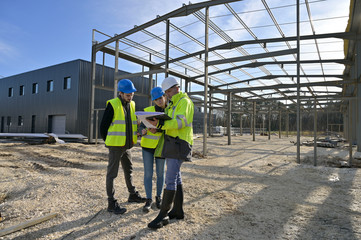 Engineering instructor working on building site with apprentice