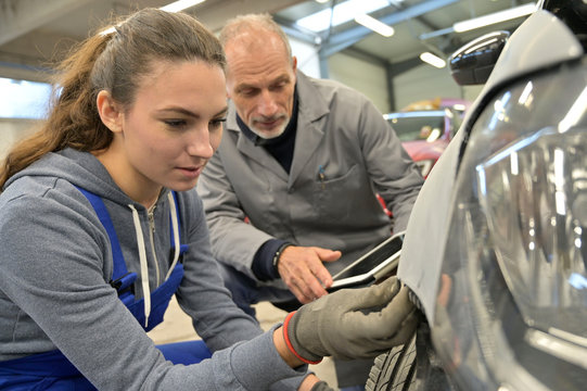 Apprentice With Instructor Working On Vehicle