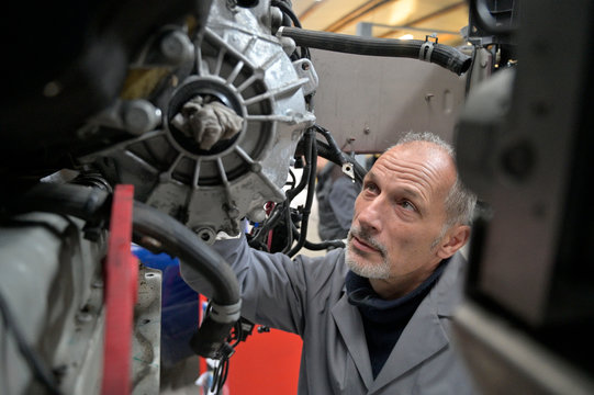 Engineering technician checking vehicle in workshop