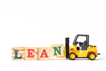 Toy forklift hold wood letter block n to complete word lean on white background