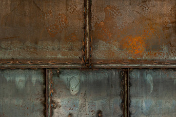 Background from a steel wall from sheets of iron welded together by corners. The process of rusting and destruction.