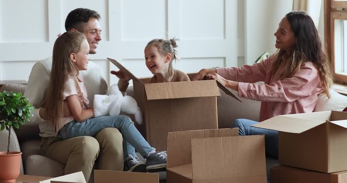 Cute kid daughter jumping out of box on moving day