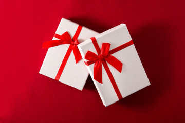 Assorted white gift boxes on red background.	Top view
