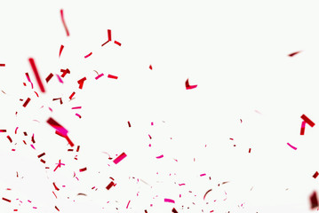 Confetti explodes on a white background. Festive salute of shiny red paper. Background decoration...