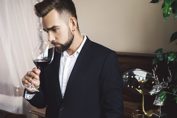 Handsome bearded man with a glass of red wine