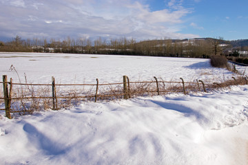 Snow drifts along the road and fence in the countryside