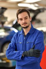 Portrait of apprentice standing in mechanics workshop