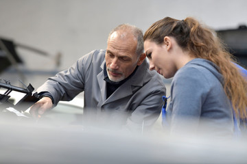 Apprentice with instructor working on vehicule
