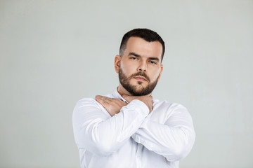 bearded man grabs his throat with both hands , pain in his throat.