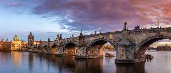 Papier Peint photo Pont Charles Prague, République tchèque - Vue panoramique sur le célèbre pont Charles (Karluv most) et l& 39 église Saint-François d& 39 Assise par un après-midi d& 39 hiver avec un beau coucher de soleil et un ciel violet