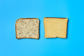 Two square pieces of bread with seeds and vanilla for toast lies on blue table on kitchen. Top view. Close-up