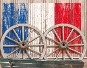 drapeau français sur fond bois, roues de charrette et banc