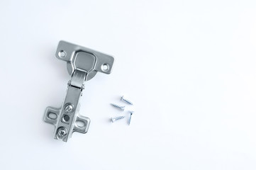 Furniture metal hinge for cabinet door and screws on a white background.