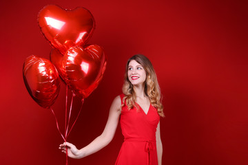 Portrait of young blonde woman posing with helium inflated air balloon. Happy valentine's day concept. Happy female with curled hair over colorful background. Close up, copy space for text.