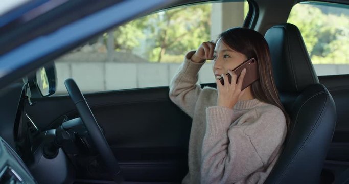 Woman talk to cellphone sit inside car