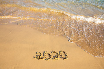 2020 summer beach holiday season written on golden sand washed away wave - new season lettering on sand - numbers 2020 year travel vacation sandy wavy water yellow blue azure aquamarine turquoise