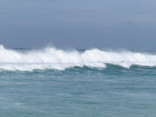 Summer morning at the beach with high tide and high winds.