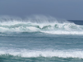 Fototapeta premium Summer morning at the beach with high tide and high winds.