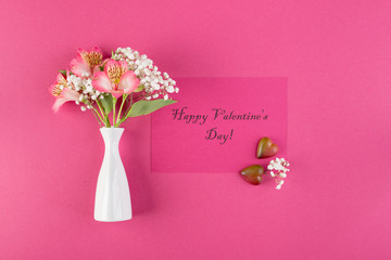 Happy Valentine's day greeting card concept. Alstroemeria flowers and the inscription Shchoslivogo Valentine's Day on a pink paper background