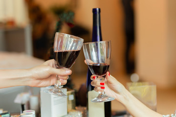 Hand clinking glasses with white wine to celebration holiday.