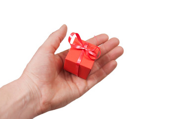 in the palm of the outstretched hand a red gift box tied with a red shiny ribbon on a white background top view
