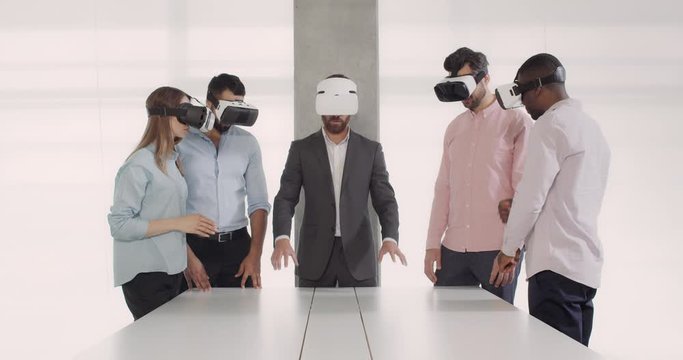 Modern team of architectures having corporate meeting using headset of virtual reality. Diverse business team in meeting room working in vr glasses. Concept of business and technology.