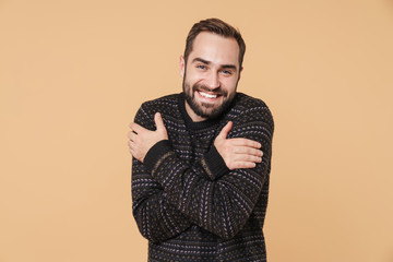 Obraz premium Cheerful young bearded man wearing warm sweater