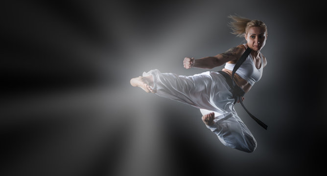 Composite image of karate girl jumping