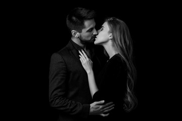 elegant couple in the tender passion. man and beautiful woman kissing. black and white