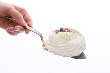 Cake on a pastry shovel in a hand isolated on a white background