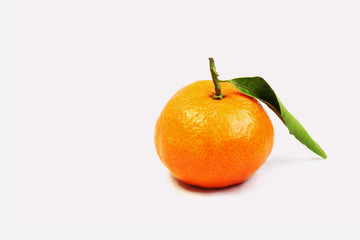 Orange mandarin with green curly leaf isolated on white background