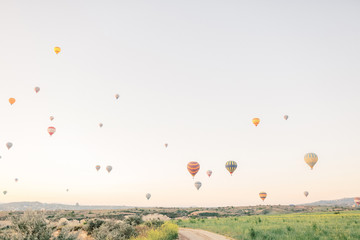 Hot air balloons flying over rock landscape in Love valley at Cappadocia, Turkey 