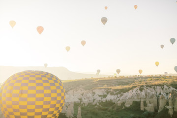 Fototapeta na wymiar Colorful hot air balloons flying over the valley in Cappadocia, Turkey