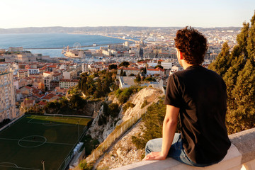 Fototapeta na wymiar Male teenage model looking over Marseille in the sunset