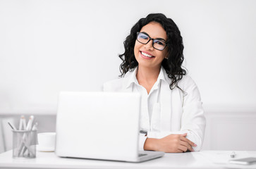 Smiling latin businesswoman working at modern office