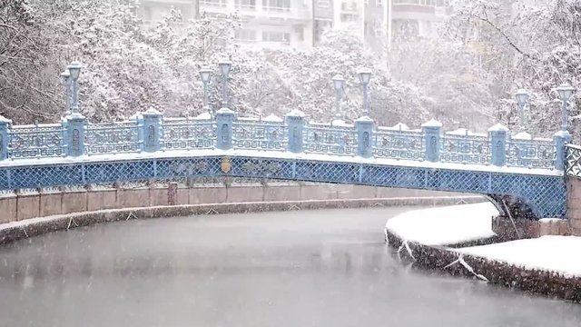 Beautiful Snow Landscape of Porsuk River with bridge and trees at the background in Winter season, in Eskisehir, Turkey. Beautiful view of snow in city center.