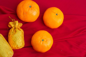 Oranges and gold on red fabric , Chinese New Year