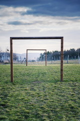 Two wooden soccer goals on green grass field, healthy active lifestyle and new years resolution concept