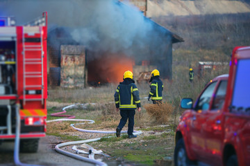 firemen rescuing a burning house