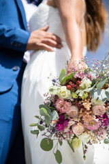 Détail de la robe de la marié avec son bouquet le jour de son mariage