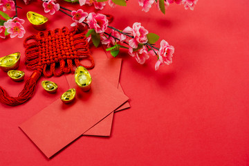 Chinese character means fortune and luck.Top view of Lunar New Year & Chinese New Year vacation concept background.Flat lay sign fortune with  pocket of money and pink cherry flower on red paper.