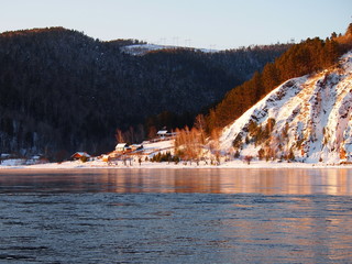 Siberian village in the winter in the mountains on the banks of the Yenisei River in the Krasnoyarsk Territory, Russia