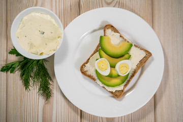 Breakfast avocado and egg toast, orange juice on wooden table. Healthy breakfast