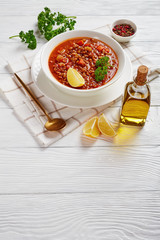 lentil soup with vegetables and lemon wedge