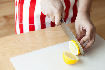 Hand using knife for cut and slide lemon